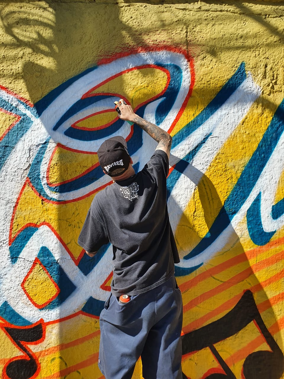 Grafiteiro grafitando muro